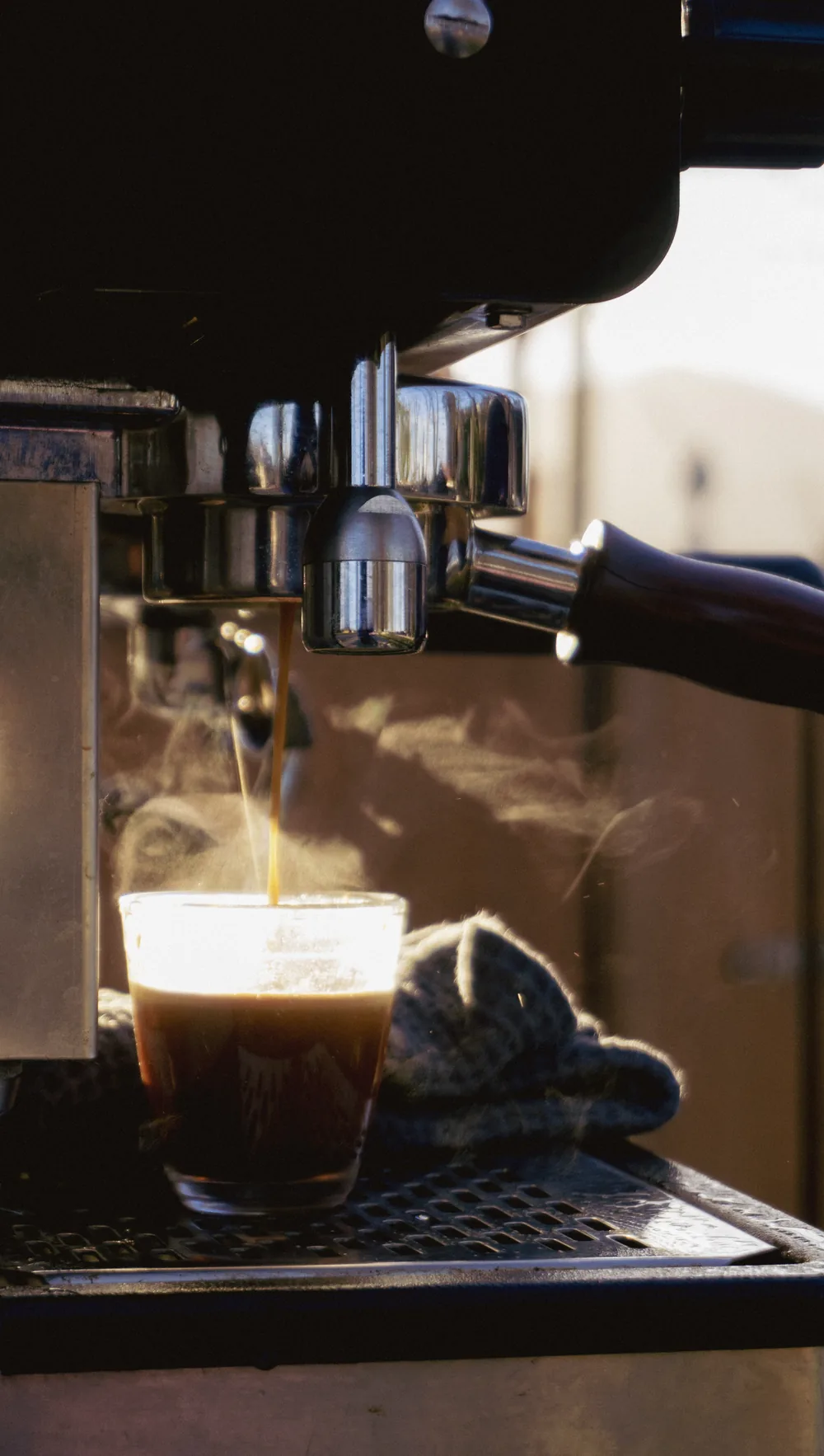 Espresso cayendo en la taza bajo el portafiltro.